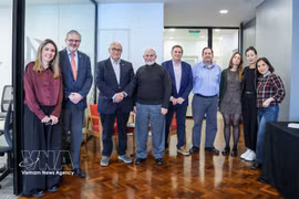 Leaders of the Buenos Aires Grain Exchange and the Argentine Soybean Chain Association pose for a photo with press representatives from countries with key agricultural ties with Argentina. (Photo: VNA)