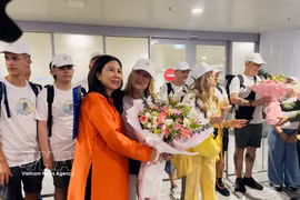 Dang Huong Giang (L), Director of the Hanoi Department of Tourism, presents flowers to Hanoi's five millionth international visitor of 2026 and her tour group from Spain at Noi Bai International Airport on the afternoon of July 7, 2026. (Photo: VNA)