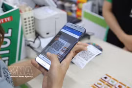 A customer conducts a QR payment. In the first eight months of the year, QR payments alone reached 10.6 billion USD. (Photo: VNA)