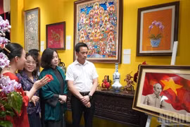 Delegates admire an embroidered portrait of President Ho Chi Minh at the launch ceremony (Photo: nhandan.vn)