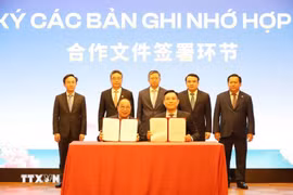 Representatives of Vietnamese and Chinese businesses sign a cooperation agreement at the forum. (Photo: VNA)