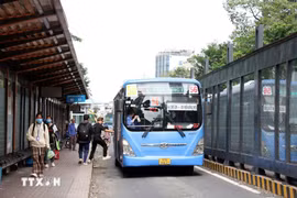 Passengers get on a bus on Ham Nghi street in Ho Chi Minh City. (Photo: VNA)