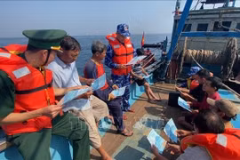 Soldiers from Coast Guard Region 3 and Border Guard provide legal information to fishermen. (Photo: VNA)