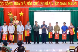 Prime Minister Pham Minh Chinh presents gifts to policy beneficiary families in De Gi commune. (Photo: VNA)