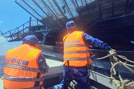Officers and soldiers aboard Ship 314 approach the distressed fishing vessel QNa 91117 TS (Photo: VNA) 