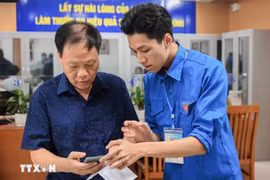 Guiding a local how to apply for administrative procedures on a mobile phone (Photo: VNA)