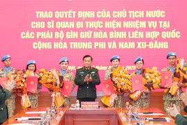 Deputy Minister of National Defence Sen. Lieut. Gen. Hoang Xuan Chien (C) hands over the State President's decisions to the officers. (Photo: VNA)