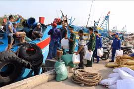 Officers of the Dong Thap provincial Border Guard give gifts and provide information on IUU fishing control and prevention to fishermen at Vam Lang fishing port, Gia Thuan commune, Dong Thap province. (Photo: VNA)