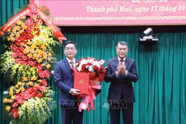 Politburo member, Secretary of the Party Central Committee, and Chairman of its Organisation Commission Le Minh Hung (R) hands overs the decision to Nguyen Dinh Trung at a ceremony on October 17, 2025 (Photo: VNA)