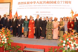 Participants pose for a group photo at the September 30 reception celebrating the 77th founding anniversary of China. (Photo: qdnd.vn)