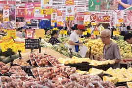 Consumers buy fruit at a supermarket in Vietnam. (Photo: VNA)