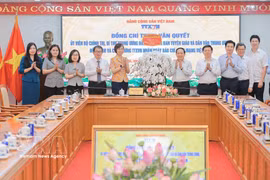 Head of the Party Central Committee’s Commission for Information, Education and Mass Mobilisation Trinh Van Quyet presents congratulatory flowers to VNA (Photo: VNA)