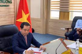 Acting Minister of Agriculture and Environment of Vietnam Tran Duc Thang signs the agreement (Photo: VNA)