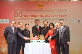 Vietnamese Ambassador to Singapore Tran Phuoc Anh (fourth, right), Singapore's Coordinating Minister for Public Services and Minister for Defence Chan Chun Sing (fifth,right) and Vietnamese Ambassadors who have served in Singapore cut the cake to celebrate the National Day (Photo: VNA)