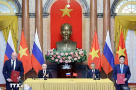 Then State President To Lam (second from right) and Russian President Vladimir Putin witness the exchange of signed documents between the two countries on June 20, 2024. (Photo: VNA)