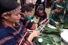 Ede women participate in wrapping "banh chung" at the programme "Green banh chung - for the poor" at the Vietnam Ethnic Culture and Tourism Village in Son Tay township, Hanoi on January 19. (Photo: VNA)