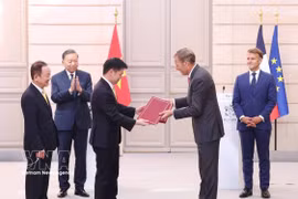 Party General Secretary and President To Lam, and French President Emmanuel Macron witness the exchange of documents and cooperation agreements between the two countries. (Photo: VNA)