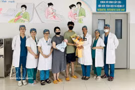 Medical staff from Da Nang Hospital for Women and Children present flowers to congratulate the couple and their baby on the child’s discharge from hospital. (Photo published by VNA)