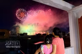 Local residents in An Hai ward, Da Nang city, watch a firework show from their house. (Photo: VNA)