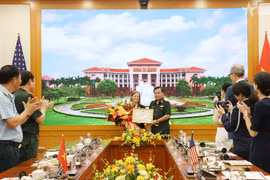 Deputy Defence Minister Senior Lieutenant General Hoang Xuan Chien (R) presents a certificate of merit from the Minister of National Defence of Vietnam to USAID's Mission Director for Vietnam Aler Grubbs (Photo: VNA)