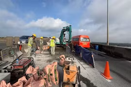 Workers close part of Long Thành Bridge for expansion joint repairs on Wednesday. The HCM City–Long Thành Expressway will be partially closed until mid-August. (Photo courtesy of VECE)