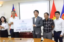 A representative of the Vietnam–Cambodia Business Association (VCBA) presents its donated fund to the leaders of the Vietnamese Ambassador to Cambodia Nguyen Minh Vu (2nd from left). (Photo: VNA)