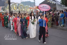 Women join the parade featuring more than 2,000 participants dressed in lotus-patterned “ao dai” on June 27, part of the Hanoi Lotus Festival 2026. (Photo: VNA)