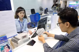 A customer conducts a transaction at an office of a bank in Hanoi (Photo: VNA)