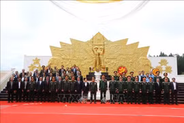 Delegates pose for a group photo at the Vietnam-Laos combat alliance monument in the southern Lao province of Champasak on July 1. (Photo: VNA)