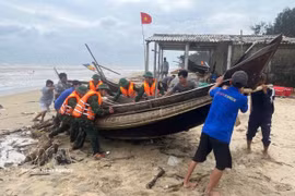 Pulling a boat ashore to shelter from the storm (Photo: VNA)