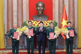 State President Luong Cuong (C) hands over the decisions to promote Members of the Party Central Committee and the Central Military Commission, and Deputy Defence Ministers Nguyen Hong Thai, Nguyen Van Hien and Nguyen Truong Thang; and Deputy Chief of the General Staff of the VPA Nguyen Quang Ngoc, from the rank of Lieutenant General to Senior Lieutenant General. (Photo: VNA)