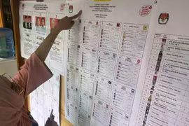 Voter checks the list of presidential and legislative candidates in West Java, on February 14, 2024. (Photo: Investortrust)