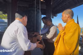 Passengers aboard the “Great Solidarity Ship” ring the bell at Da Tay A Pagoda (Photo: VietnamPlus)