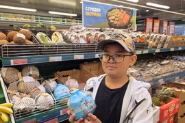 An Asian customer with a Vietnamese coconut product served with straws (Photo: VNA)