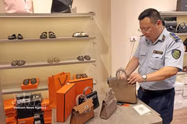 An officer of the market surveillance unit No. 2 inspects a retail outlet on Hang Dao street, Hanoi, in 2025. (Photo: VNA) 