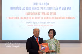 VNA General Director Vu Viet Trang (R) presents a pictorial book to PT General Secretary Alberto Anaya Gutiérrez at the meeting on August 20. (Photo: VNA)