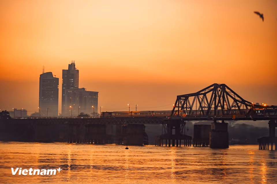 From afar, one may gaze at Long Bien Bridge, where the sunset reddens the river’s surface and watch trains slowly roll into the city. (Photo: VietnamPlus)
