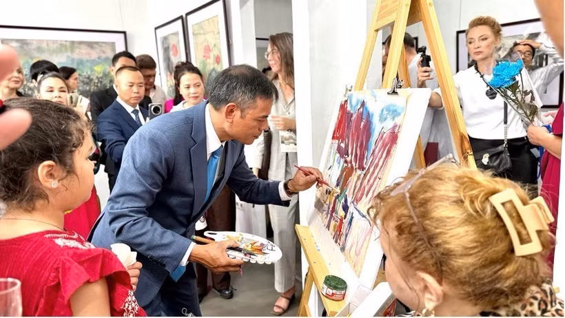 Artist Ngo Duc Hoang gives a live painting demonstration on traditional Do paper at the exhibition in Vladivostok on August 15. (Photo: VNA)