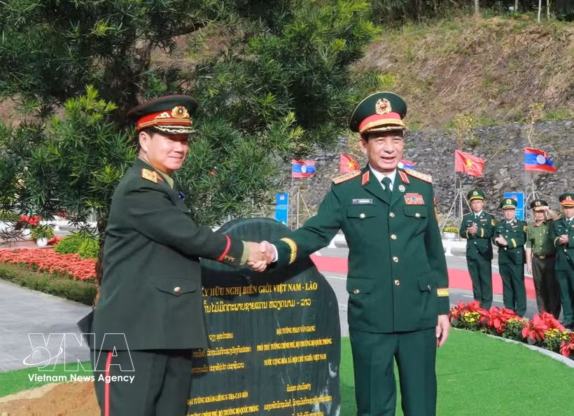 General Phan Van Giang (R) and General Khamlieng Outhakaysone plant a tree at Thanh Thuy border gate. (Illustrative photo: VNA)
