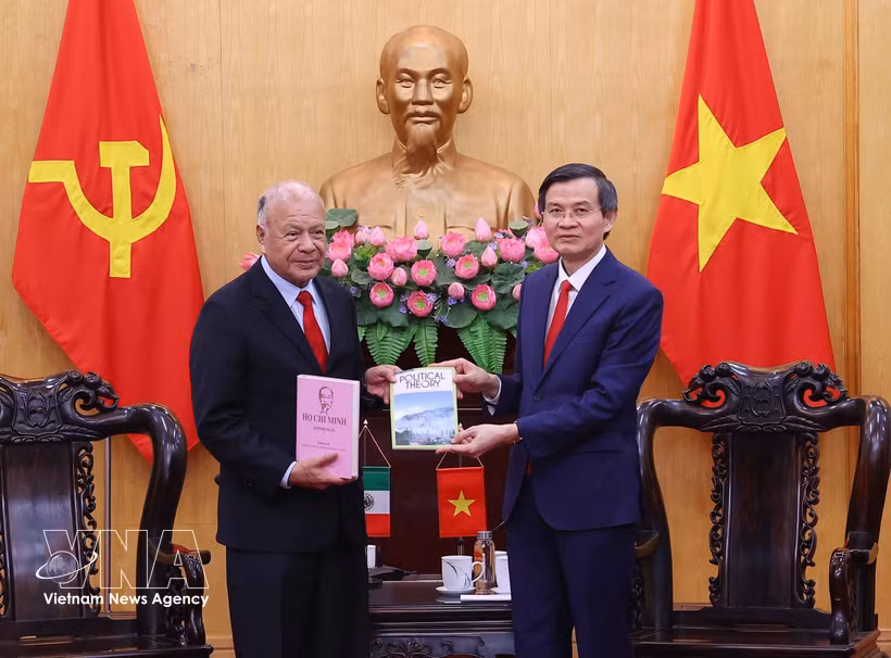 President of the Ho Chi Minh National Academy of Politics Assoc. Prof. Dr. Doan Minh Huan (R) presents books to PT General Secretary Alberto Anaya Gutiérrez at their meeting in Hanoi on August 19. (Photo: VNA)