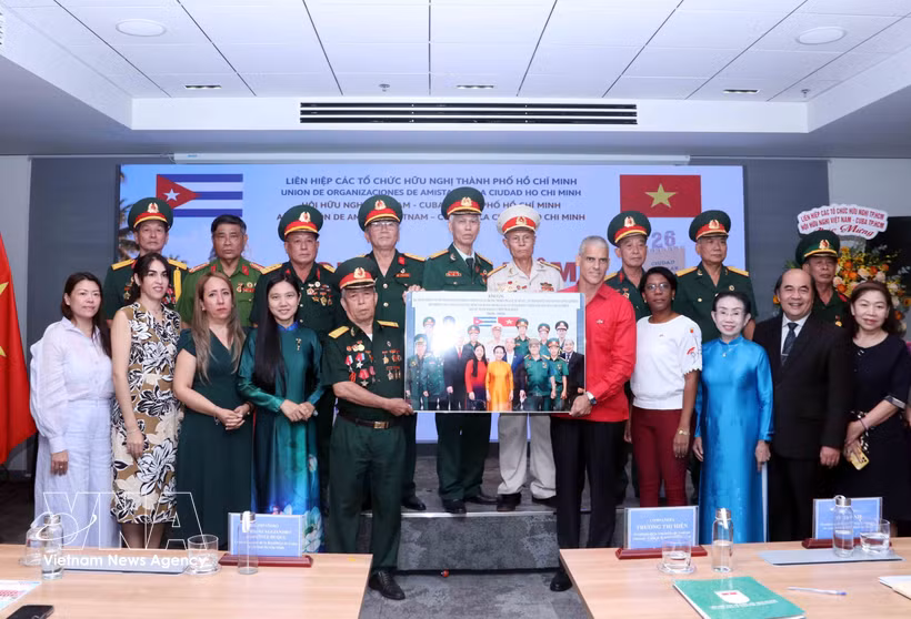Representatives of the liaison committee of veterans of Battalion 261 - Giron in Ho Chi Minh City present a commemorative photo to Mauricio Alejandro Martínez Duque, Consul General of Cuba in the city. (Photo: VNA)