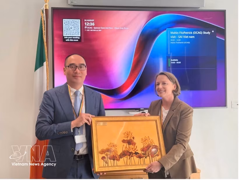 Deputy State Auditor General of the State Audit Office of Vietnam Bui Quoc Dung (left) and Secretary and Director of the Audit in the Office of the Comptroller and Auditor General of Ireland Colette Drinan exchange souvenirs. (Photo: VNA)