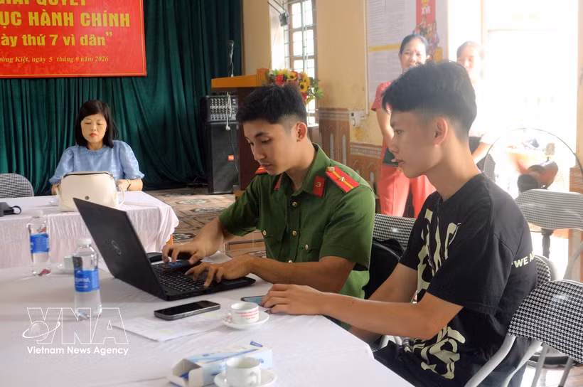 A police officer guides a citizen on how to use VNeID app. (Photo: VNA)