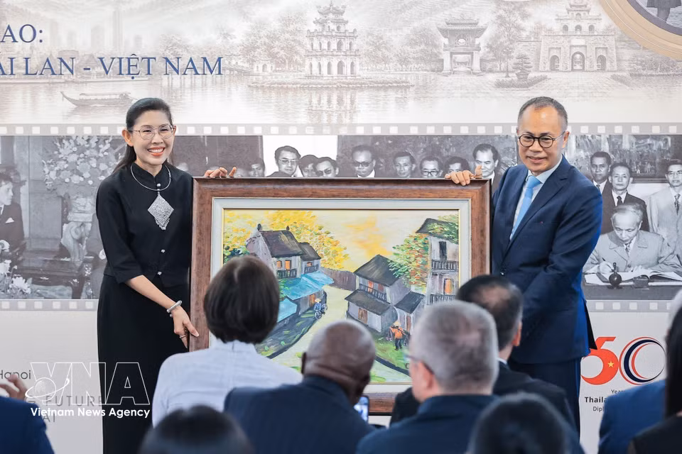 Phan Chi Thanh, former Vietnamese Ambassador to Thailand, presents a commemorative painting to the Thai Ambassador to Vietnam, Urawadee Sriphiromya. (Photo: VNA)