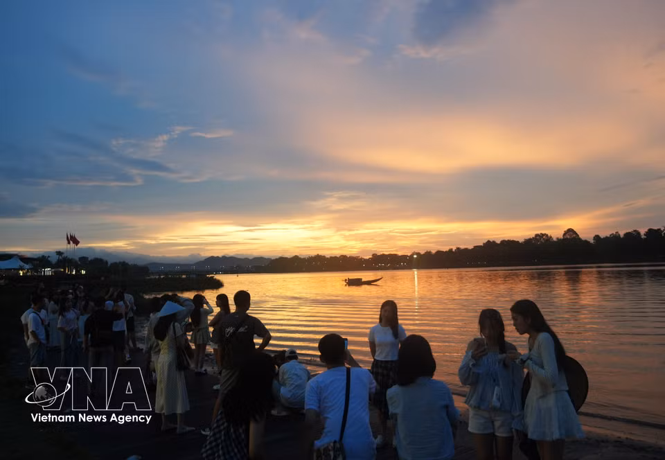 Tourists enjoy the sunset along the Perfume River in Hue City. (Photo: Nguyen Ly/VNA)