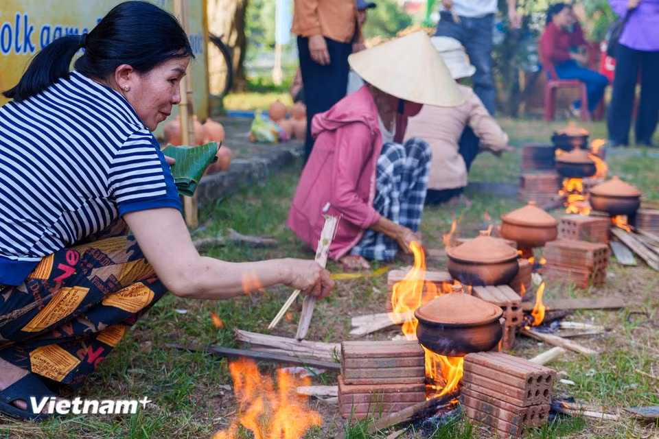 Contestants skilfully adjust the wood fire to ensure the rice is cooked evenly while retaining its distinctive flavour. (Photo: Thanh Phong/Vietnam+)
