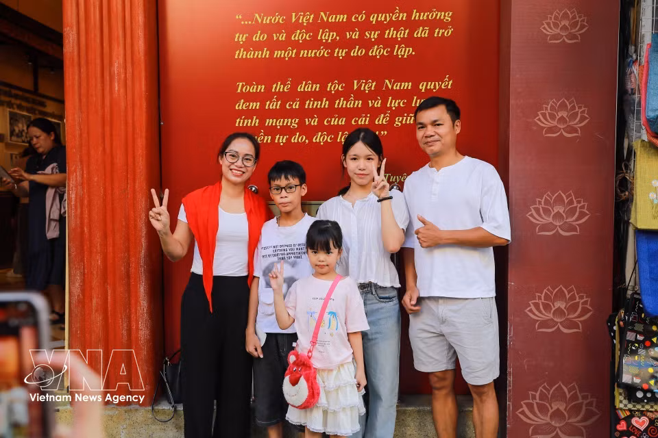 A family takes photos to capture memories at 48 Hang Ngang Street. (Photo: Khanh Hoa/VNA)