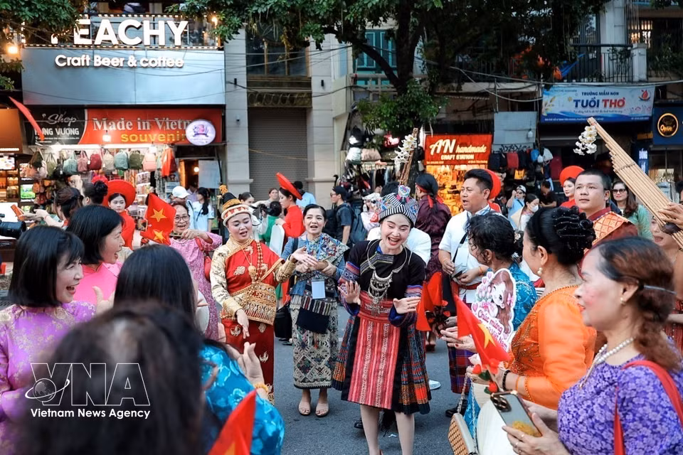 Members of the Lao delegation interact with Vietnamese people amid the lively atmosphere of the “Colours of the World” street festival in the Hoan Kiem Lake pedestrian area. (Photo: VNA)