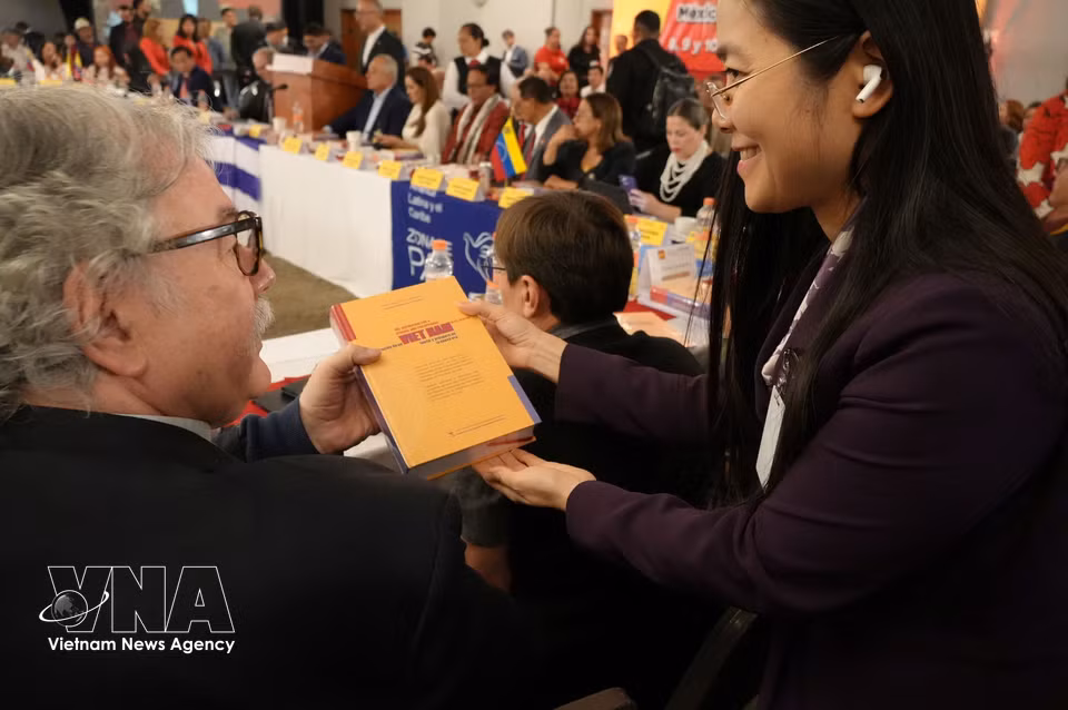 Copies of the book “The Aspiration for a Strong and Prosperous Vietnam in the New Era” are presented to heads of delegations attending the seminar. (Photo: Phi Hung/VNA correspondent in Mexico)