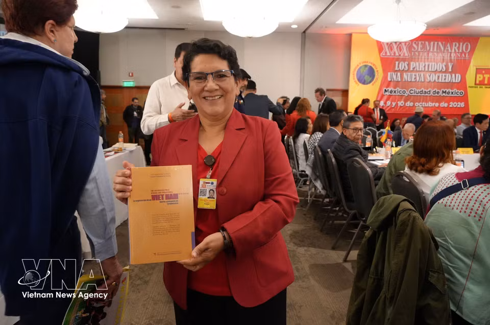 The head of the Paraguayan delegation is delighted to receive a copy of the book. (Photo: Phi Hung/VNA correspondent in Mexico)